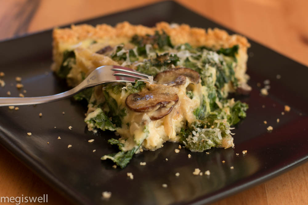 Sautéed mushrooms, onions, and French cream make this Kale, Onion, and Mushroom Quiche creamy while the kale adds a slight crunch and a crumbly almond flour crust melts in your mouth. Perfect for breakfast, brunch, lunch, and dinner! | www.megiswell.com 