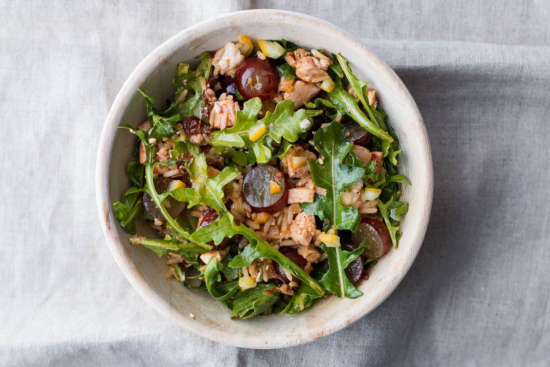 This Leftover Chicken Bowl Recipe is an easy and quick way to get rid of leftovers. Brown rice, sun dried tomatoes, preserved lemon, feta, grapes, and arugula combine for a light, healthy, and filling bowl. | www.megiswell.com