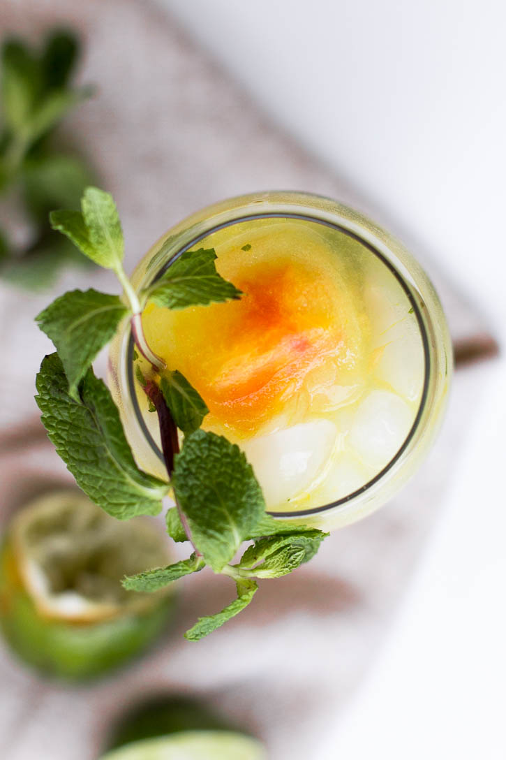 Put a sweet summer twist on the classic mojito by adding fruity simple syrup ice cubes, creating a sweet icy slush at the end of this Orange Pomelo Turmeric Mojito | www.megiswell.com