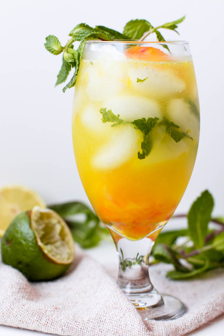 Put a sweet summer twist on the classic mojito by adding fruity simple syrup ice cubes, creating a sweet icy slush at the end of this Orange Pomelo Turmeric Mojito | www.megiswell.com