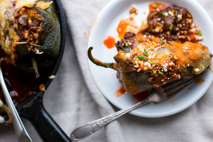 Use your leftover turkey (or chicken) in these Turkey Enchilada Stuffed Poblano Peppers. Turkey and brown rice are smothered in a homemade red enchilada sauce and topped with melty cheese. | www.megiswell.com
