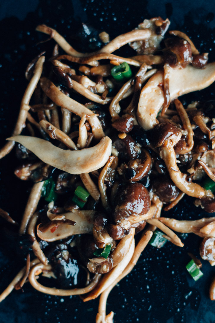 Overhead shot of sautéed mushrooms and green onions in a pile on a baking sheet.