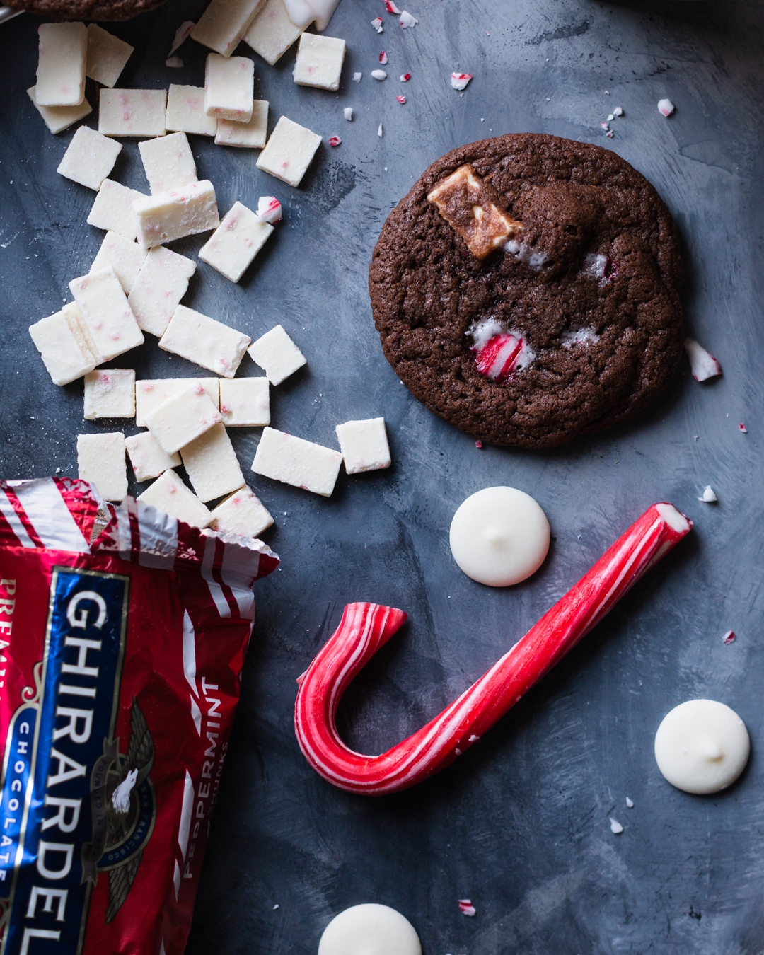 Overhead shot of cookie surrounded by a candy cane, peppermint chips, and white chocolate wafers.