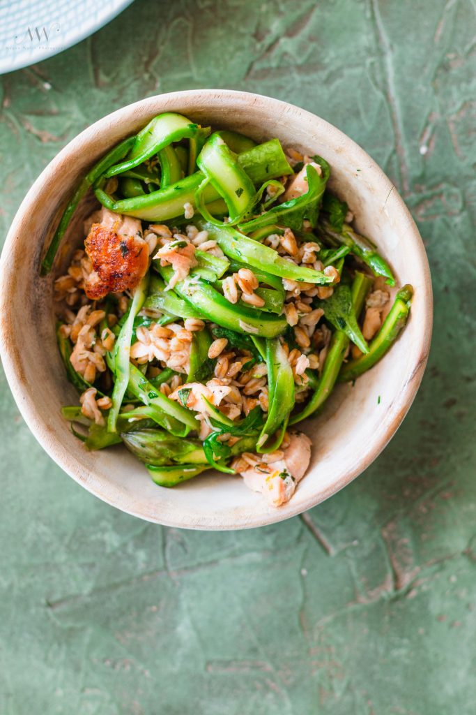 Overhead shot of asparagus, farro, and salmon in a bowl.