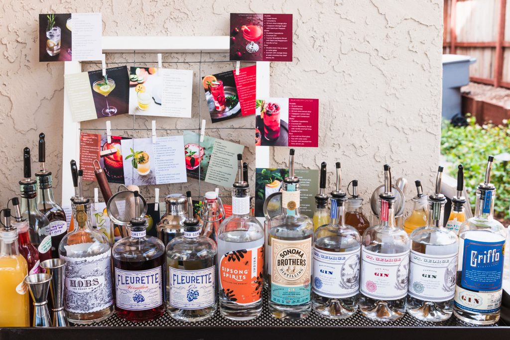 Horizontal shot of the DIY Gin Bar with gins, bar tools, shrubs, and syrups.