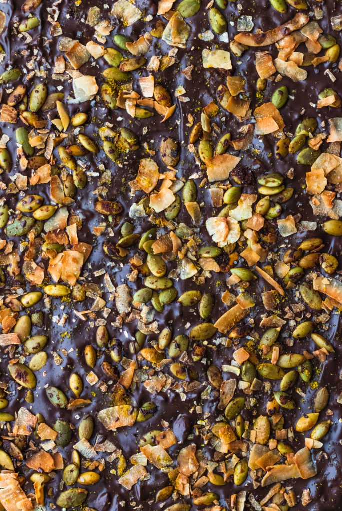  Close up overhead shot of chocolate bark covered with toppings. 