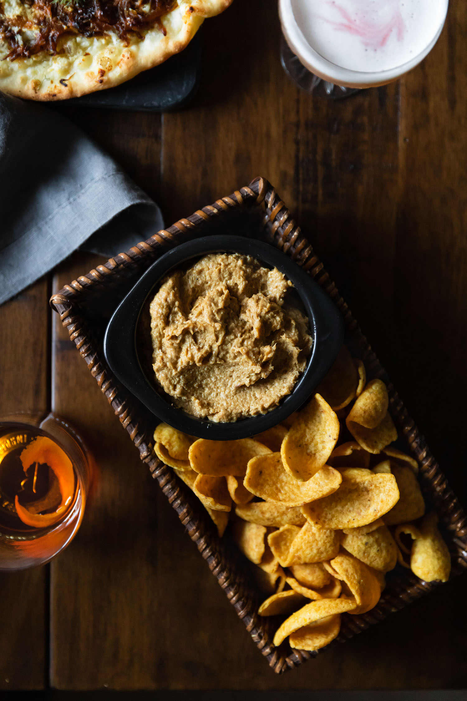 Overhead shot of caramelized onion dip in a basket with Fritos.