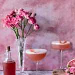 Fresh Grapefruit French 75s arranged in front of roses and simple syrup.